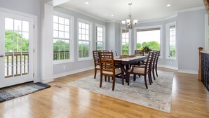 A dining room with a large table, wooden chairs, and a chandelier. - Mountain Views, Hot Tub, Game Room | 20 min to Asheville! One Mile to Mars Hill University! (Mars Hill)