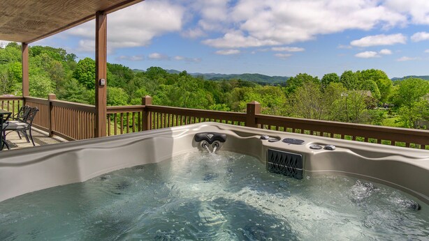 A hot tub with a wooden deck and a scenic view of mountains and trees. - Mountain Views, Hot Tub, Game Room | 20 min to Asheville! One Mile to Mars Hill University! (Mars Hill)