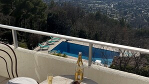 A table with food and drinks on a balcony overlooking a pool and distant landscape. - 5 bedroom villa with sea view in Tourettes (Tourrettes-sur-Loup)