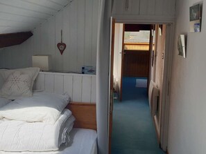 A bedroom with a bed, a bedside table, a lamp, and a wall-mounted heart decoration. - Duplex for 6/7, city center, near cable car (Cauterets)
