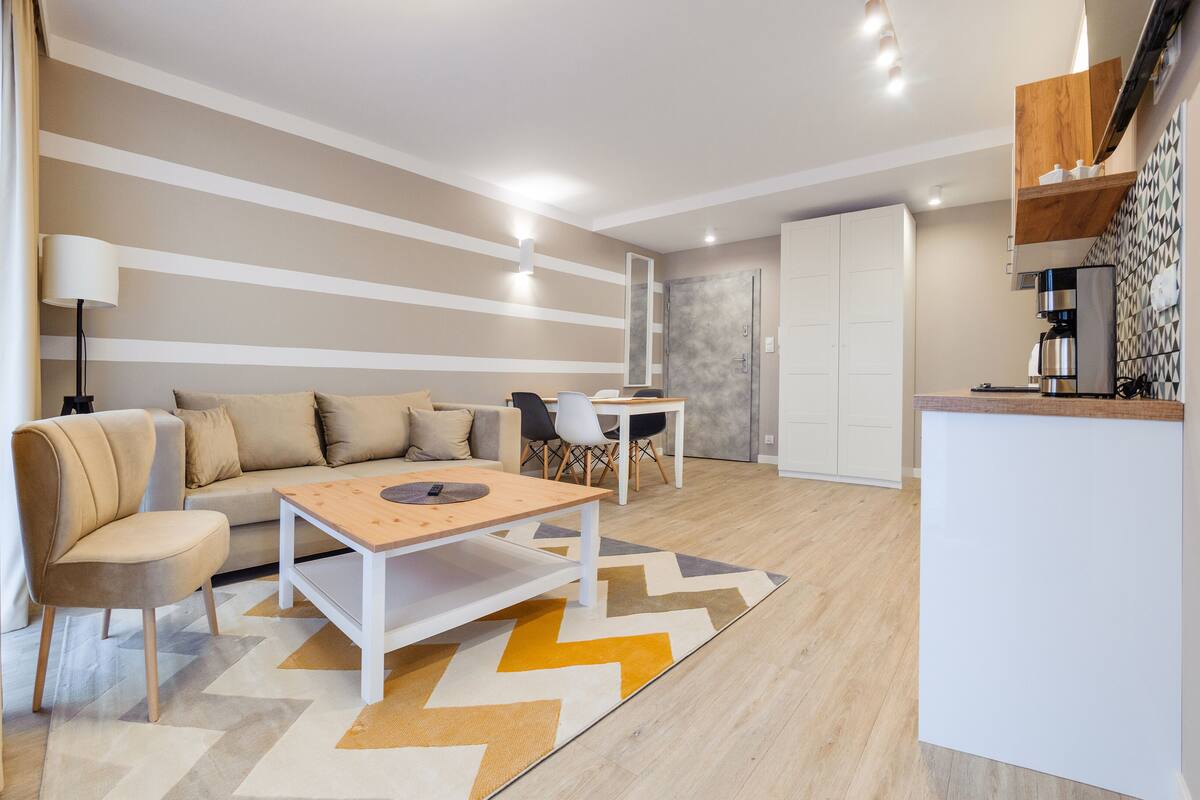 Un salon moderne avec un canapé, une table basse et un coin repas.
