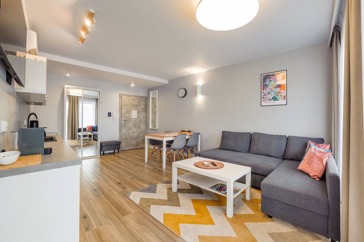 Un salon moderne comprenant un canapé, une table à manger et un coin cuisine.