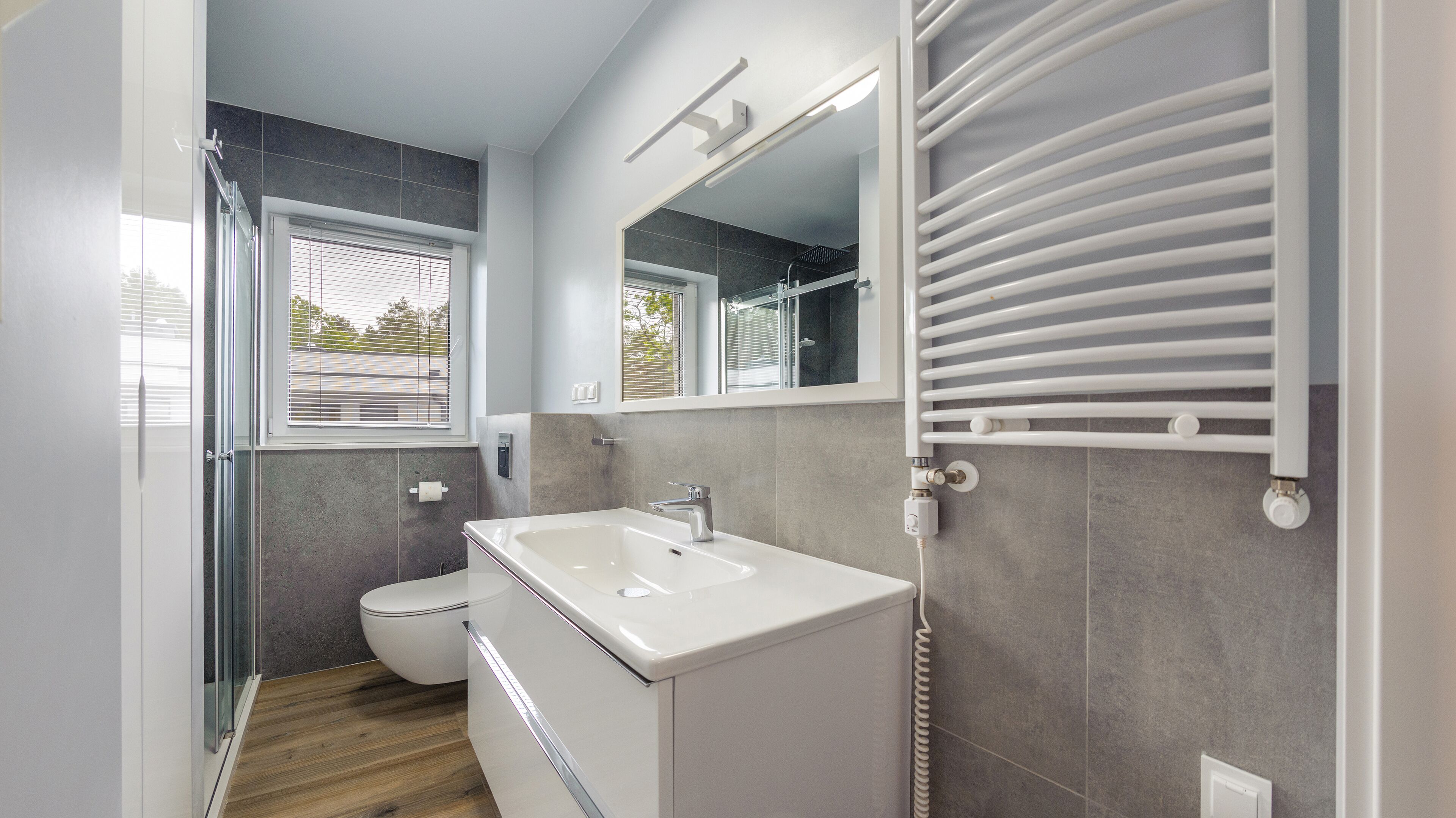A modern bathroom with a shower, toilet, and sink.