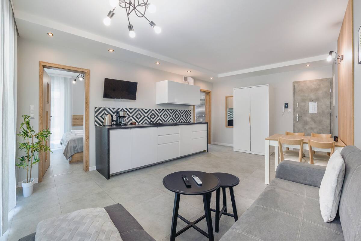 Un appartement moderne comprenant une cuisine, un coin repas et un salon.
