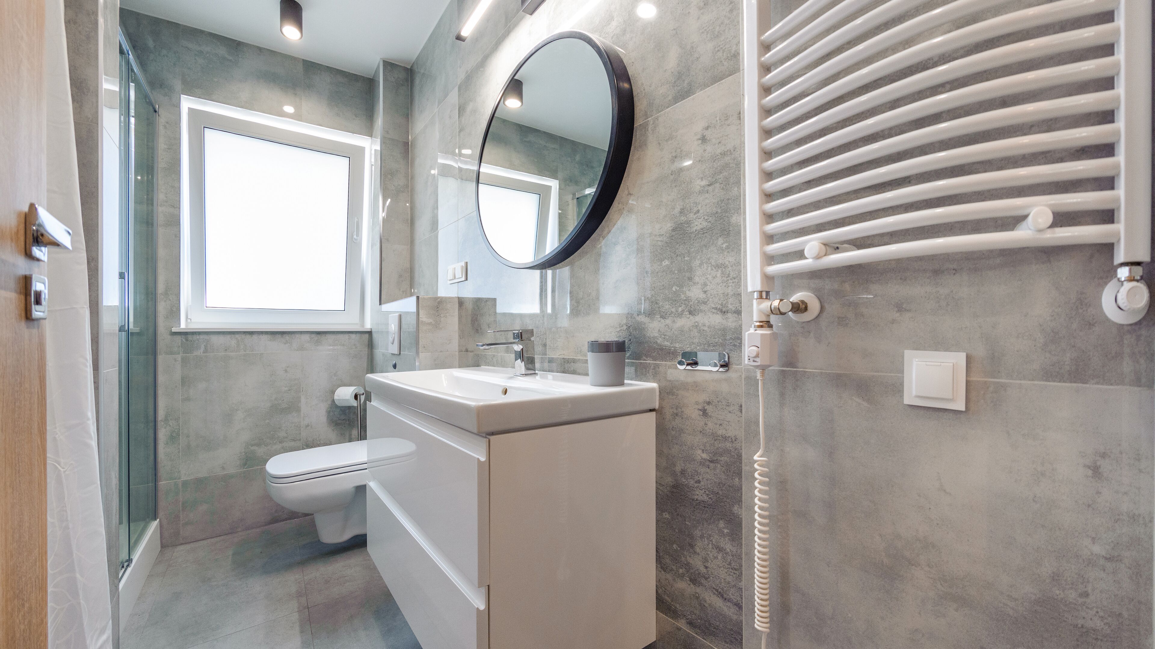 Un bagno moderno con il water, un lavandino e uno specchio.