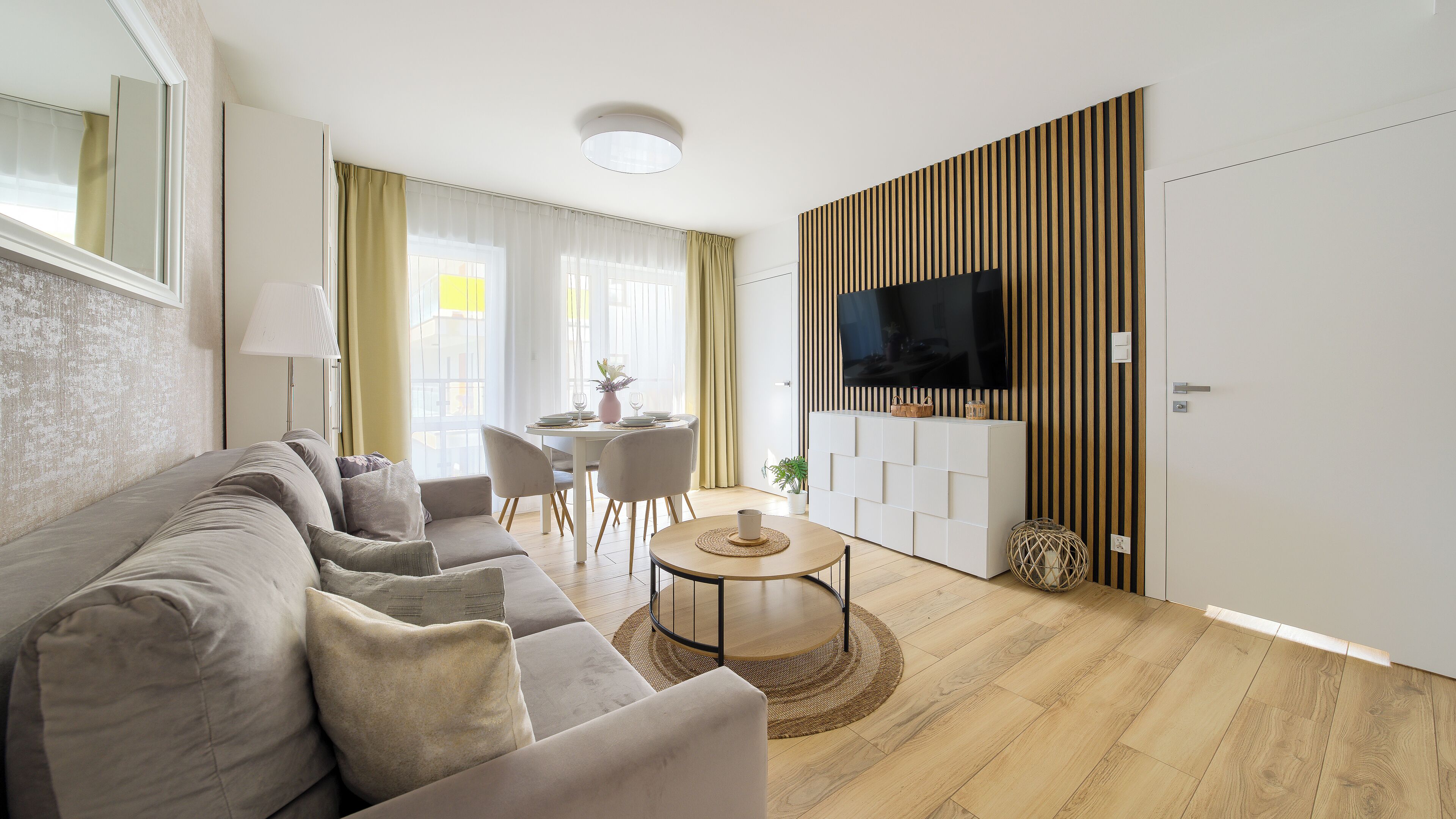 Un salon moderne avec un canapé, une table à manger et un téléviseur.