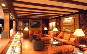 A cozy lounge area with sofas, armchairs, and a television. - Hotel Palacio Matutano Daudén (La Iglesuela del Cid)