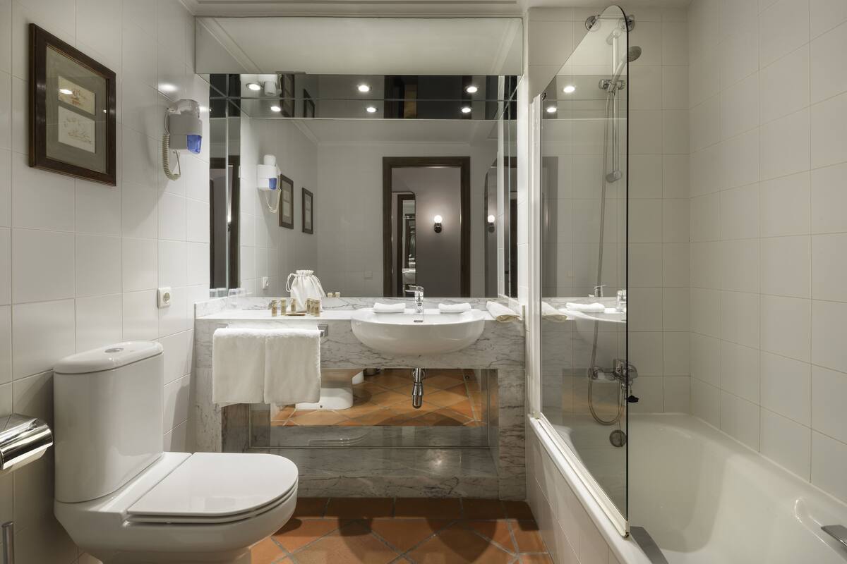 A modern bathroom with a toilet, sink, and shower.