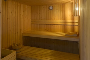 A sauna with wooden benches and a visible thermometer on the wall. - Hotel Palacio Matutano Daudén (La Iglesuela del Cid)