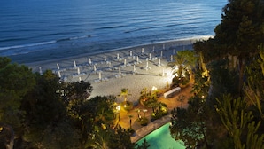 A beach resort with rows of sunbeds, a swimming pool, and a view of the sea. - Aeneas' Landing Resort (Gaeta)