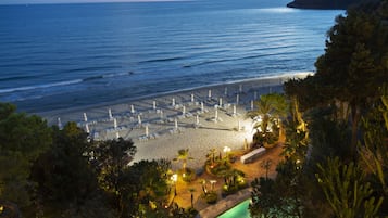 Pantai pribadi, pasir putih, kursi berjemur, dan payung pantai