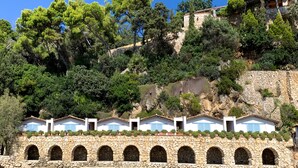 A coastal hotel with stone arches and a stone wall, overlooking a beach and dense greenery. - Aeneas' Landing Resort (Gaeta)