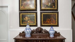 A dining table with two blue and white vases and four framed paintings on the wall above. - THE VILLAR HOUSE (Estación de Brazatortas-Veredas)