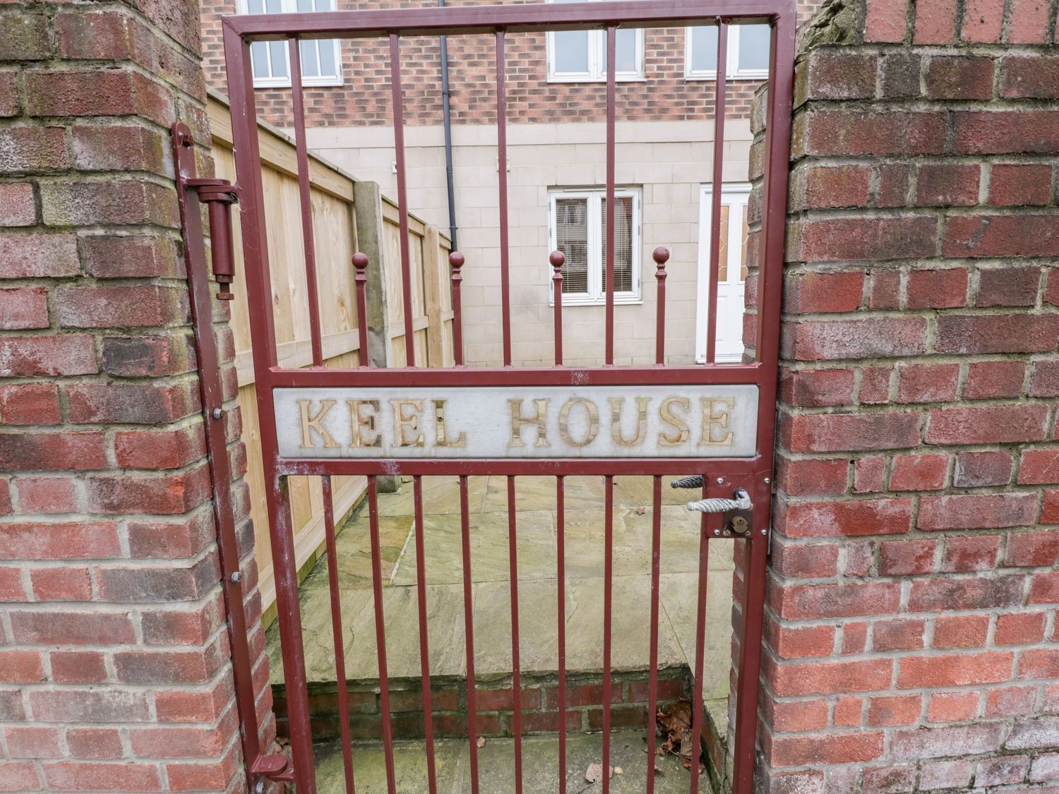 En hegnet indgang med et skilt, der viser "KEEL HOUSE".