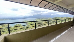 A balcony with a view of a lake and mountains. - Hilltop Retreat (Pune)
