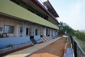 A multi-story building with a flat roof and a balcony on the upper floor. - Hilltop Retreat (Pune)