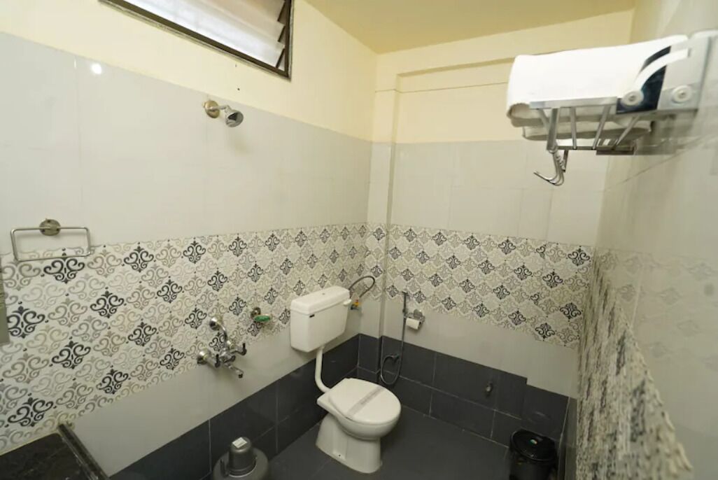A bathroom with a toilet, sink, and a towel rack.