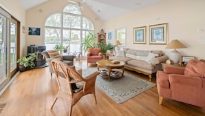 A spacious living room with a large window, a fireplace, and comfortable seating.