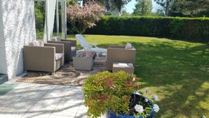 Un espace extérieur aménagé avec des meubles en osier et un tapis à motifs.