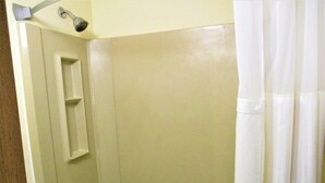 A bathroom with a shower, a towel rack, and a door. - Marifah Inn (Williamsburg)