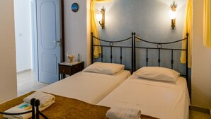 Ein Hotelzimmer mit zwei Betten, einem Nachttisch und einer Tür.