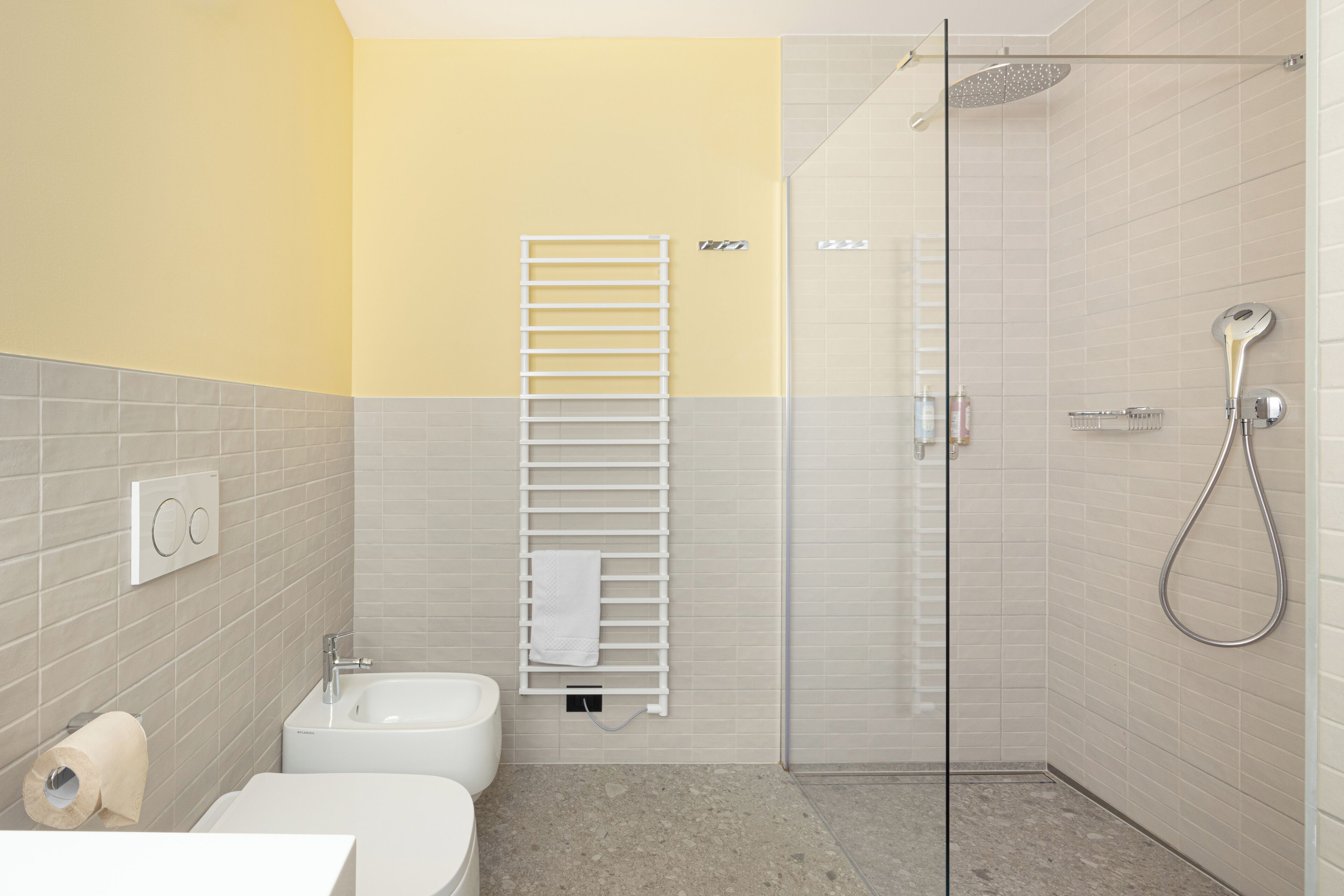 A modern bathroom with a glass shower enclosure, a white sink, and a toilet.