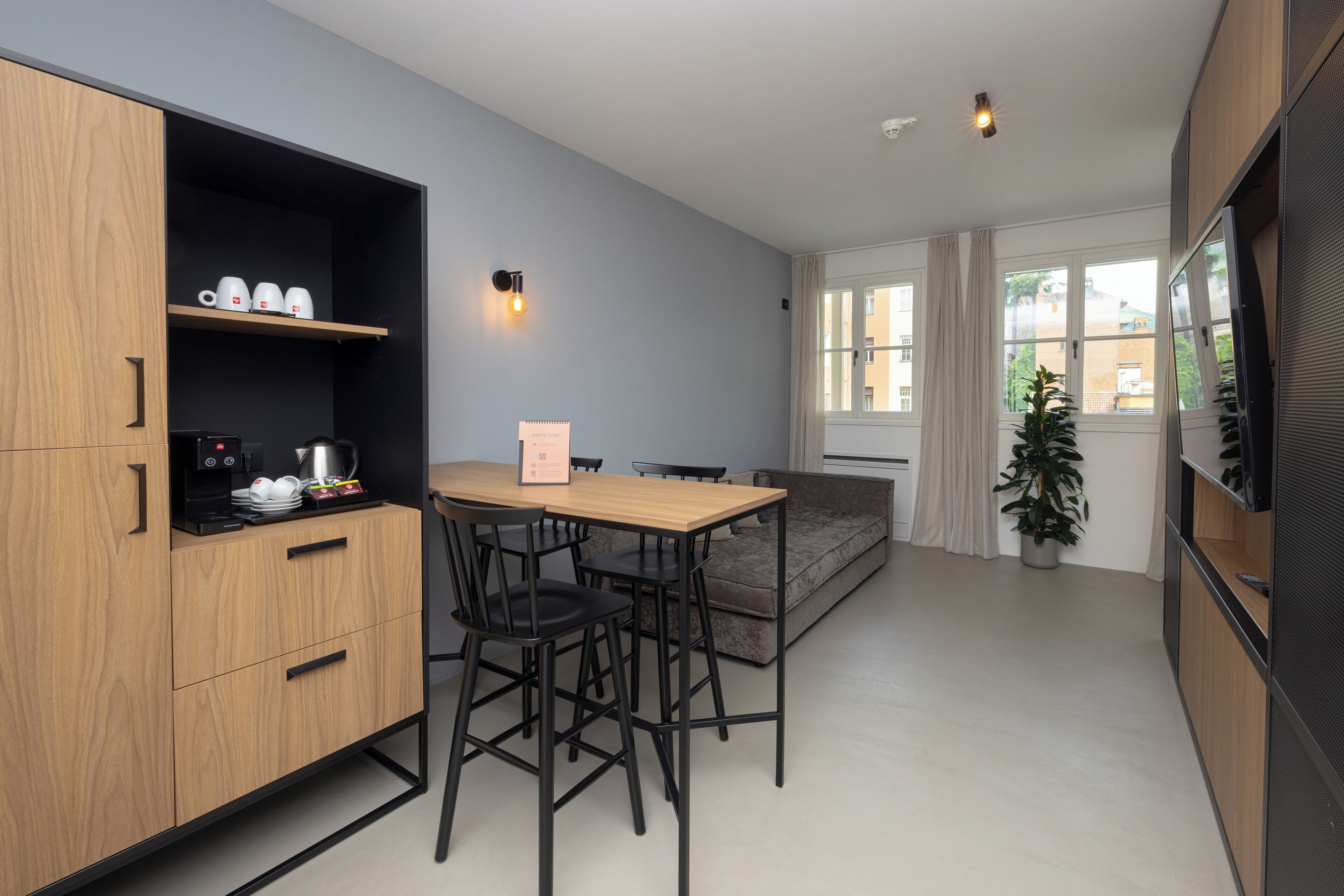 Una cocina moderna con armarios de madera, una cafetera y una mesa de comedor con sillas.