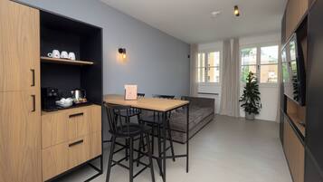 Una cocina moderna con armarios de madera, una cafetera y una mesa de comedor con sillas.