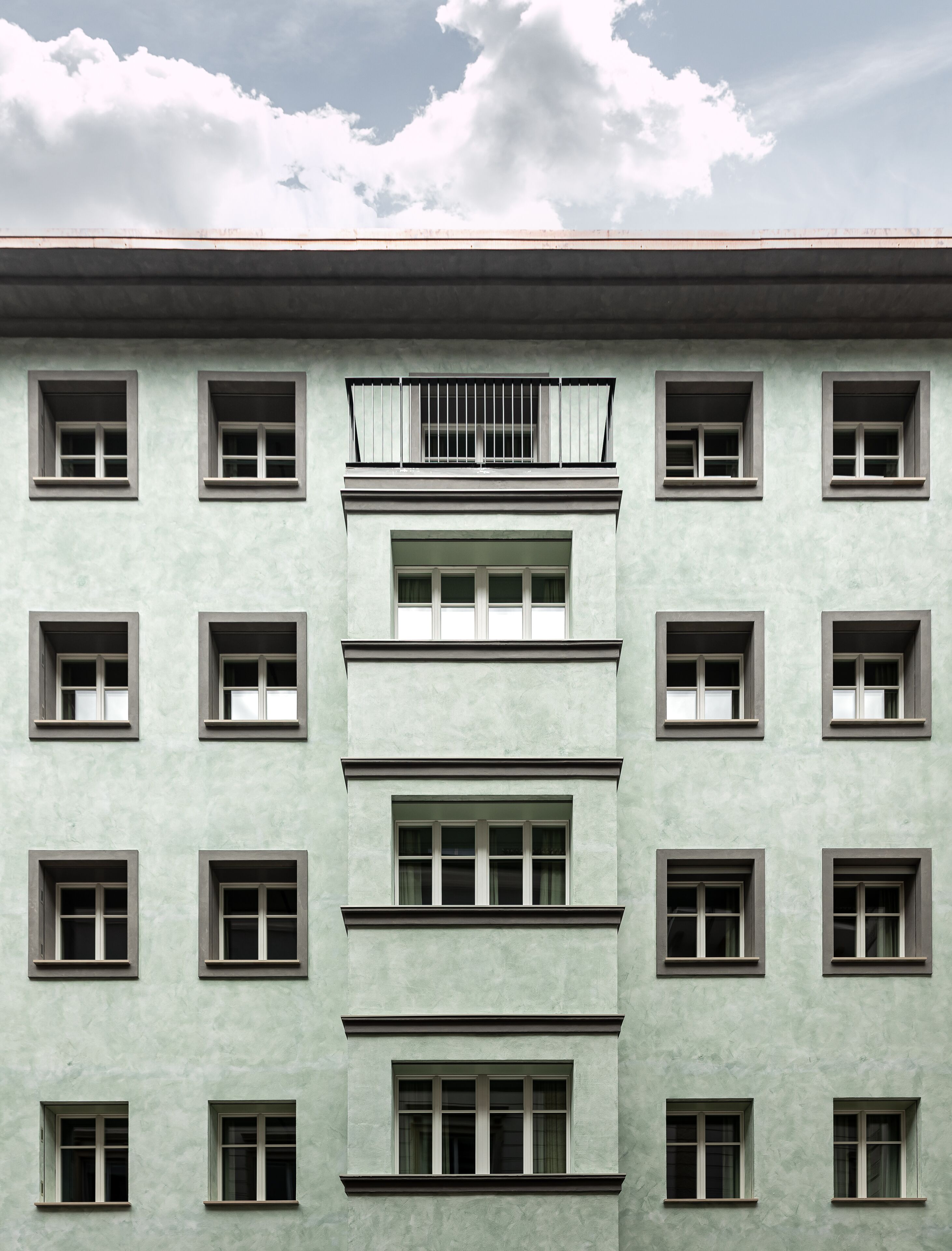 A multi-story building with a symmetrical facade, featuring evenly spaced windows and balconies.