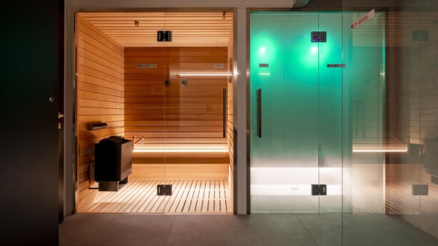 A modern elevator with wooden paneling and a green-lit interior. - Residence - Palais Hörtenberg (Bolzano)