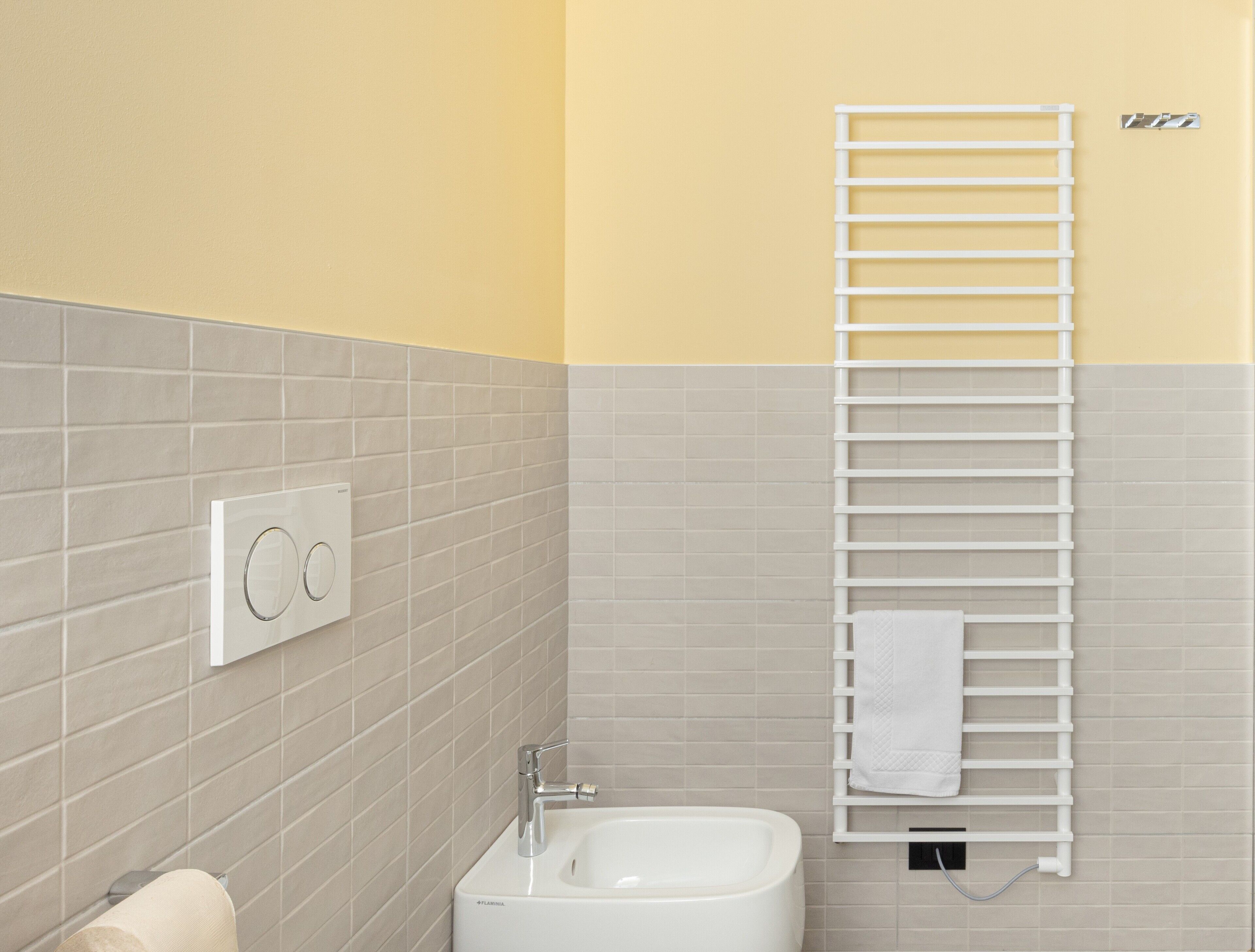 Une salle de bain avec un lavabo blanc, un porte-serviettes et des toilettes.