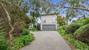 A modern two-story house with a paved driveway leading to a garage. - Aireys Delight (Aireys Inlet)