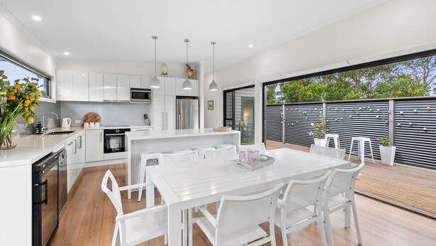A modern kitchen with white cabinetry, stainless steel appliances, and pendant lighting. - Aireys Delight (Aireys Inlet)