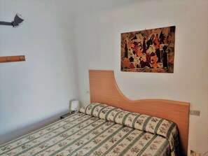 Restful retreat with a floral-patterned bed and a beautiful painting above.