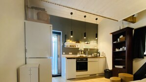 Eine moderne Küche mit weißen Geräten, Holzböden und Pendelleuchten.