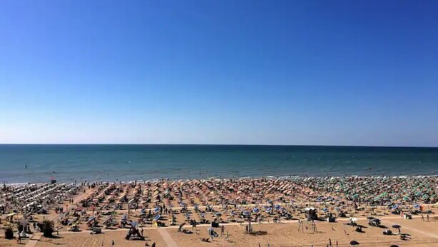 A crowded beach with numerous umbrellas and people. - Lido dei Pini three-room apartment sleeps 6 (Bibione)