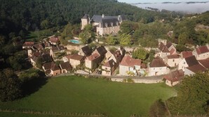 Un domaine historique comprenant un grand manoir, une piscine et des bâtiments résidentiels environnants.