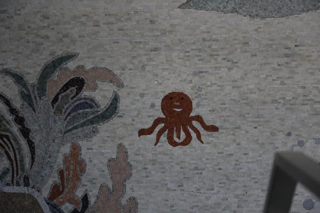 A mosaic with an octopus and plant elements.