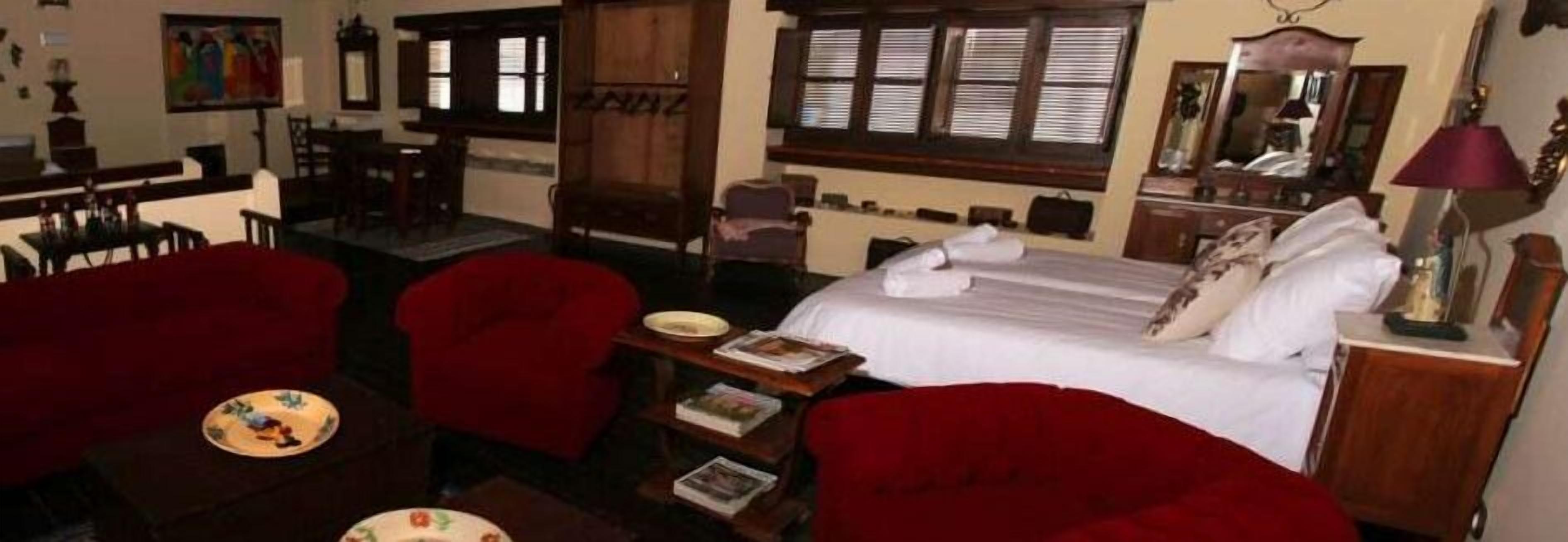 Une pièce comprenant un lit, un bureau, une chaise et une petite table avec une assiette et des livres.