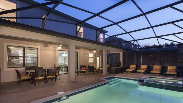 Une piscine dotée d’un toit en verre, d’un espace salon extérieur et d’un patio.