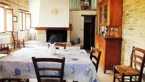 A dining area with a brick wall, a fireplace, and a wooden cabinet. - Farmhouse in the Quiet of the Countryside, Multi-family (Marche)