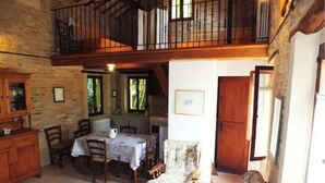 A rustic dining area with a table set for two, surrounded by wooden chairs. A wooden bench is positioned near a window, and a staircase leads to an upper level. - Farmhouse in the Quiet of the Countryside, Multi-family (Marche)