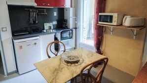 A compact kitchen with a refrigerator, microwave, toaster, and a small sink.