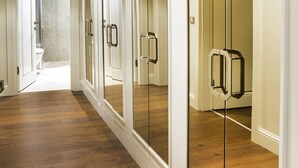 A hallway with mirrored doors, wooden flooring, and a ceiling vent. - Garlon Residence (Istanbul)