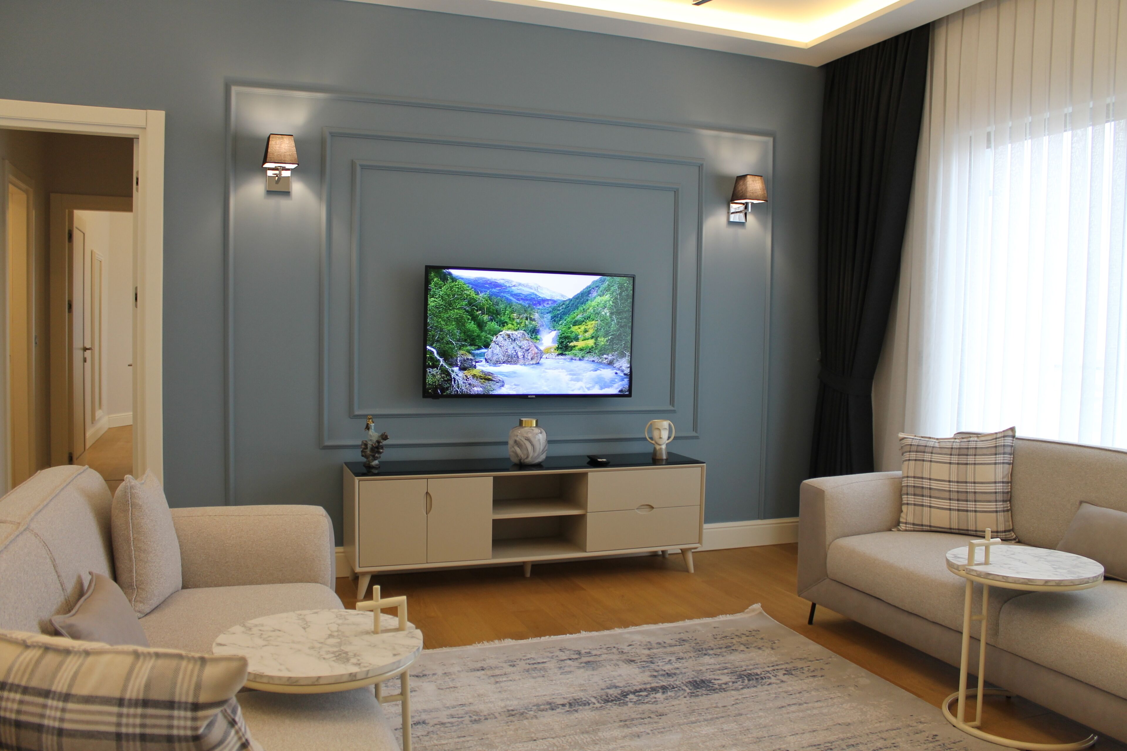 A living room with a flat-screen TV, two sofas, a coffee table, and a side table.
