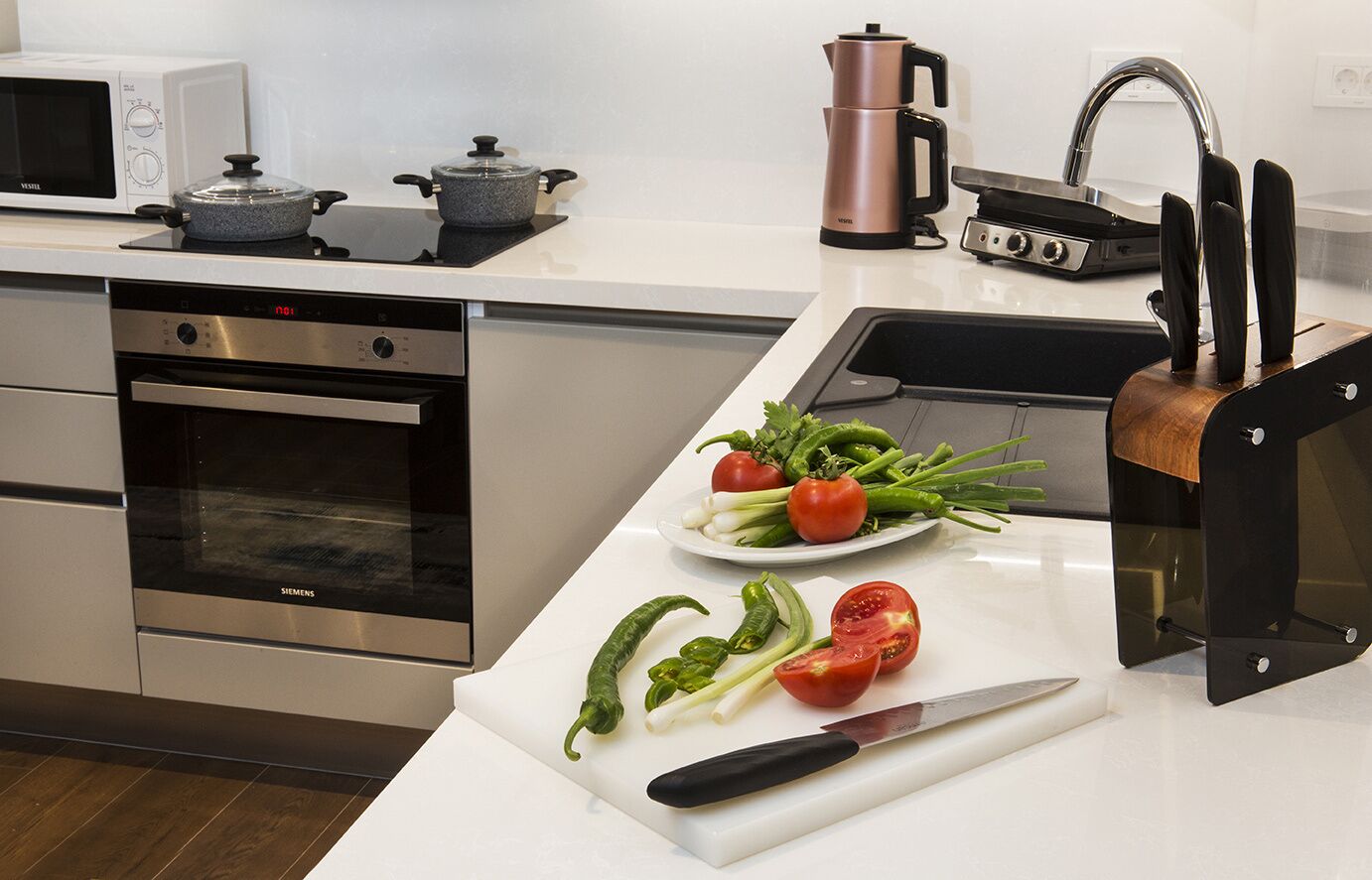 Une cuisine moderne équipée d’un four à micro-ondes, d’une cuisinière et d’une machine à café.