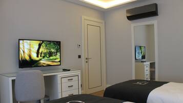 A hotel room with a bed, a desk, a chair, a television, and a wardrobe.