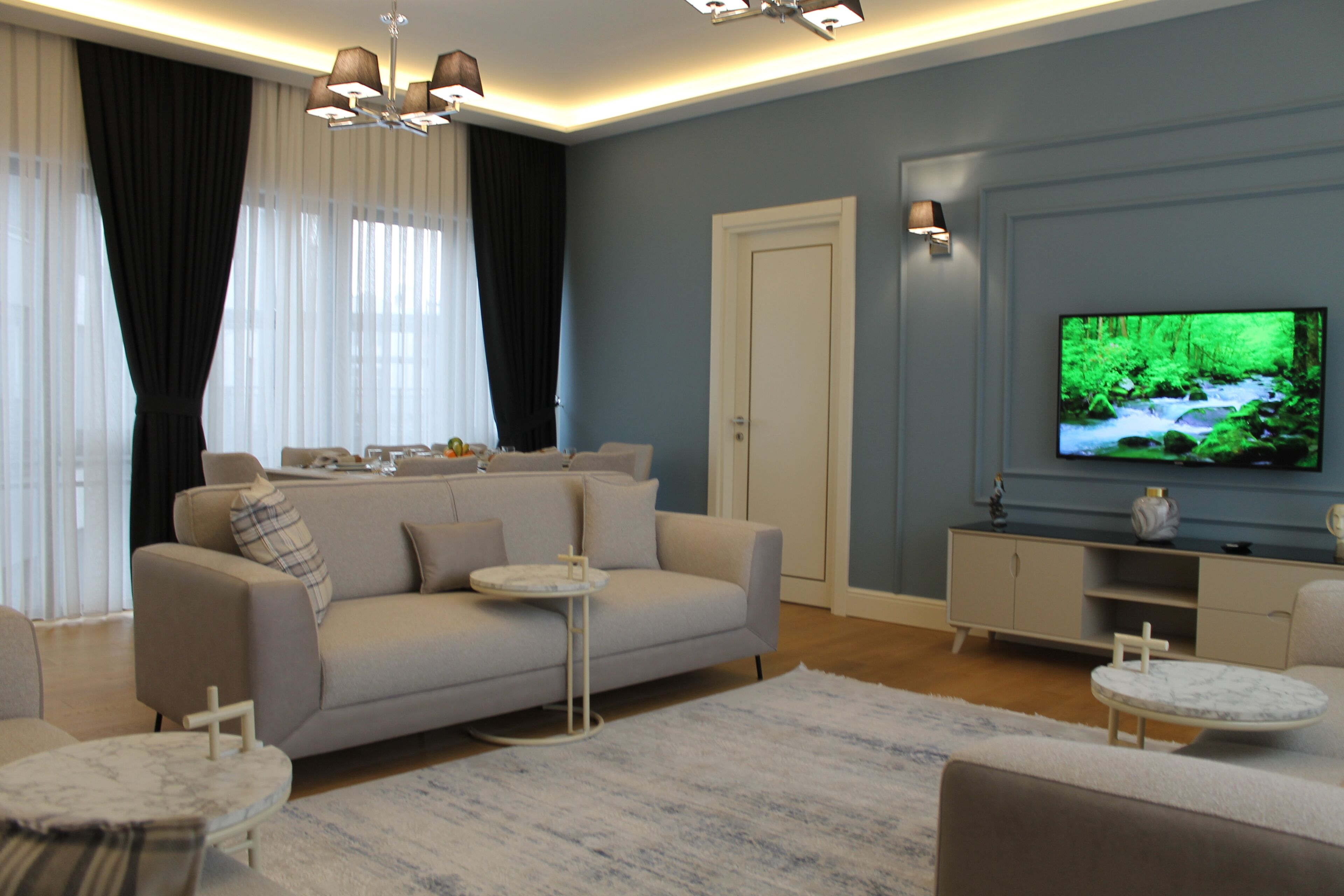 A modern living room with a sofa, a coffee table, a TV, and a cabinet.