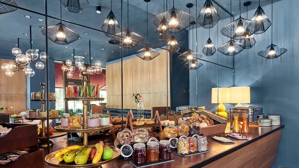Un bufé de desayuno con diversas opciones de comida y una decoración interior moderna.