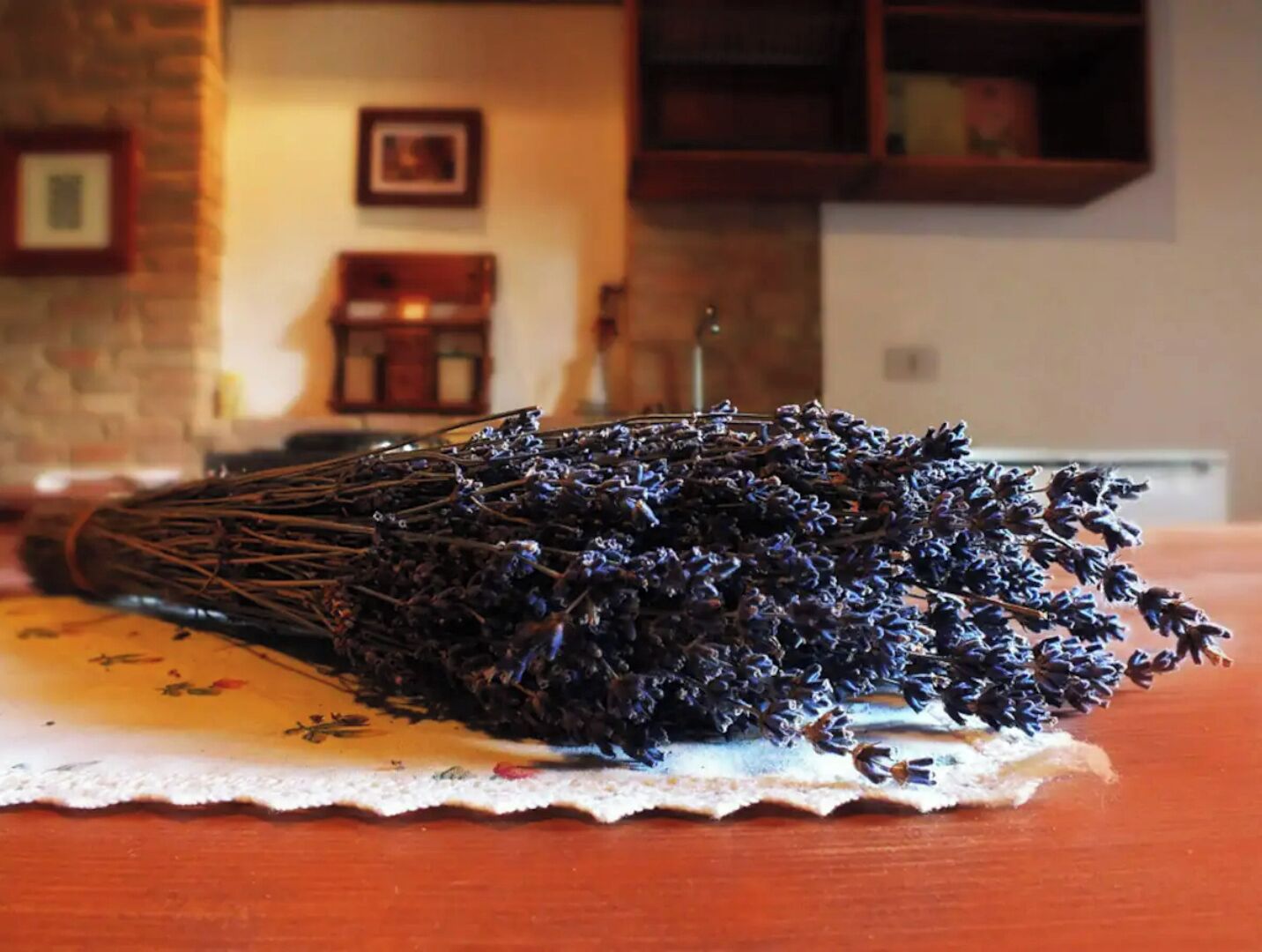 A bunch of dried lavender on a table with a lace doily.